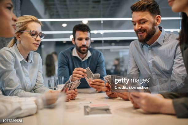 collega's playing visitekaartjes op een pauze in het kantoor. - kaartspel stockfoto's en -beelden