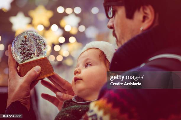 glückliche familie wahl schneekugel in weihnachten - snow globe stock-fotos und bilder