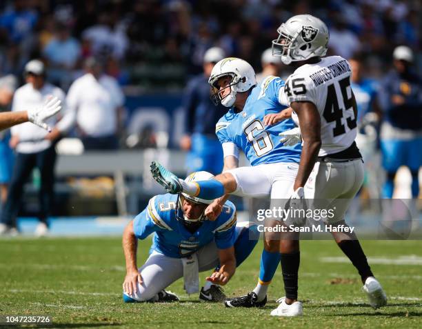 Kicker Caleb Sturgis of the Los Angeles Chargers kicks off in front of defensive back Dominique Rodgers-Cromartie of the Oakland Raiders at StubHub...