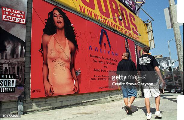 Pedestrians along Sunset Blvd look at billboard advertising the latest release of R&B singer Aaliyah who died with 8 others died in a plane crash...