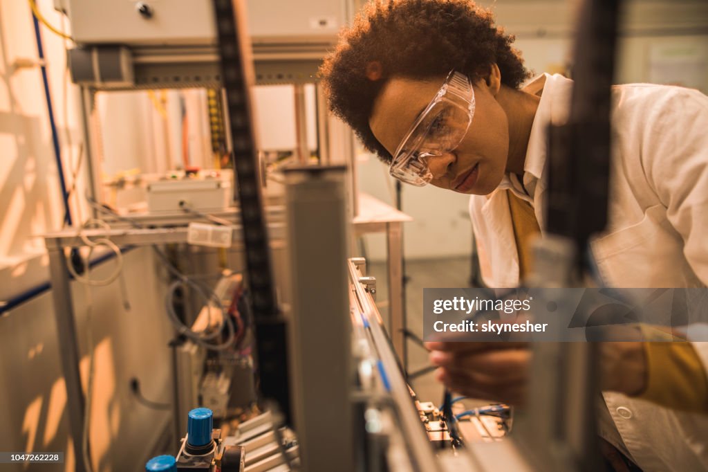 Negro mujer Ingeniero en industrial de la máquina en un laboratorio.