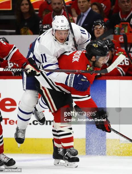 Zach Hyman of the Toronto Maple Leafs rides the back of Brent Seabrook of the Chicago Blackhawks after a collision during the regular seasopn opening...