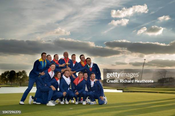 The European Team celebrate with the trophy after securing victory in the singles matches of the 2018 Ryder Cup at Le Golf National on September 30,...