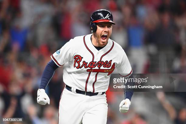 Freddie Freeman of the Atlanta Braves reacts after hitting a solo home run in the sixth inning against the Los Angeles Dodgers during Game Three of...
