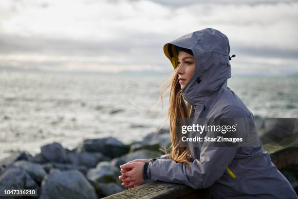 young beautiful woman wearing rain jacket in cold weather - jacket stock pictures, royalty-free photos & images