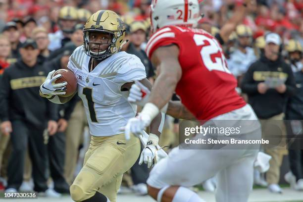 Running back D.J. Knox of the Purdue Boilermakers runs from defensive back Lamar Jackson of the Nebraska Cornhuskers at Memorial Stadium on September...