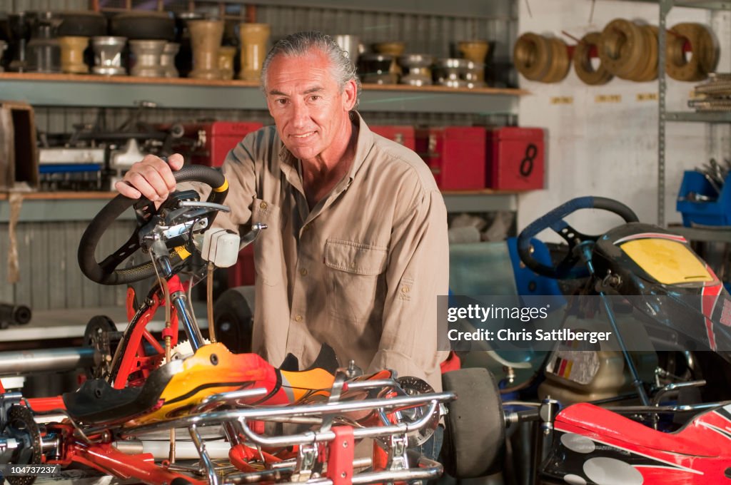 Hispanic mechanic working on go-cart