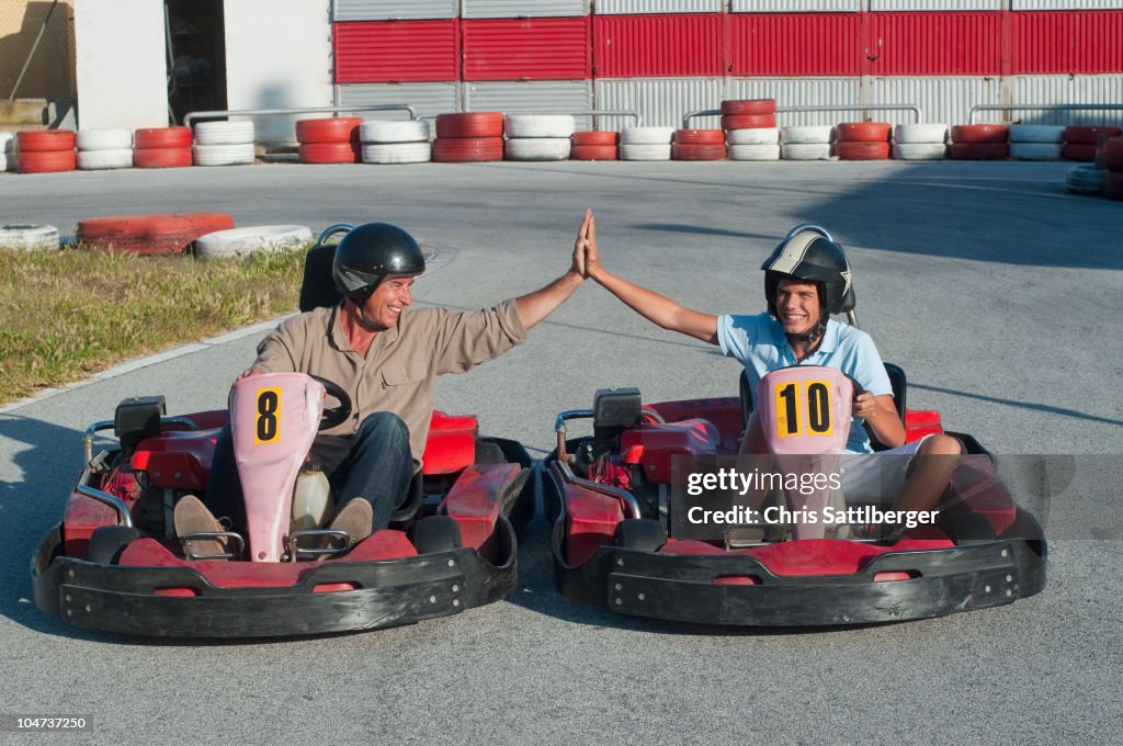 Hispanic grandfather and grandson on go-cart track