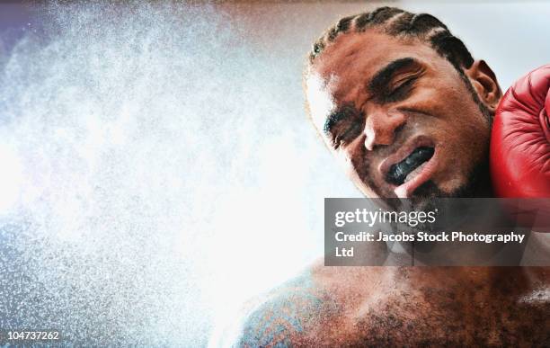 african american boxer getting hit - punsch stock pictures, royalty-free photos & images