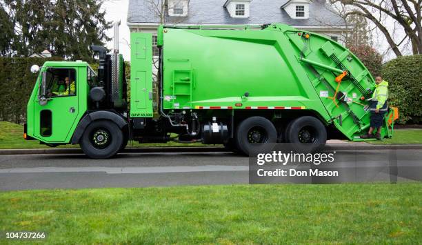 garbage men operating garbage truck - garbage collector stock pictures, royalty-free photos & images