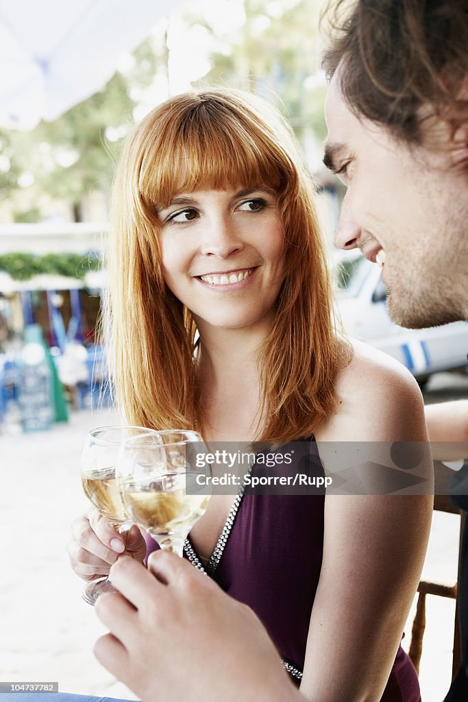 Couple clinking glasses with white wine