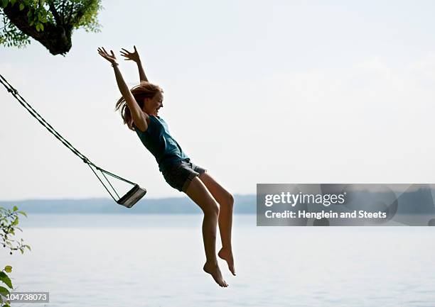 girl jumping from swing - girl jumping stock-fotos und bilder