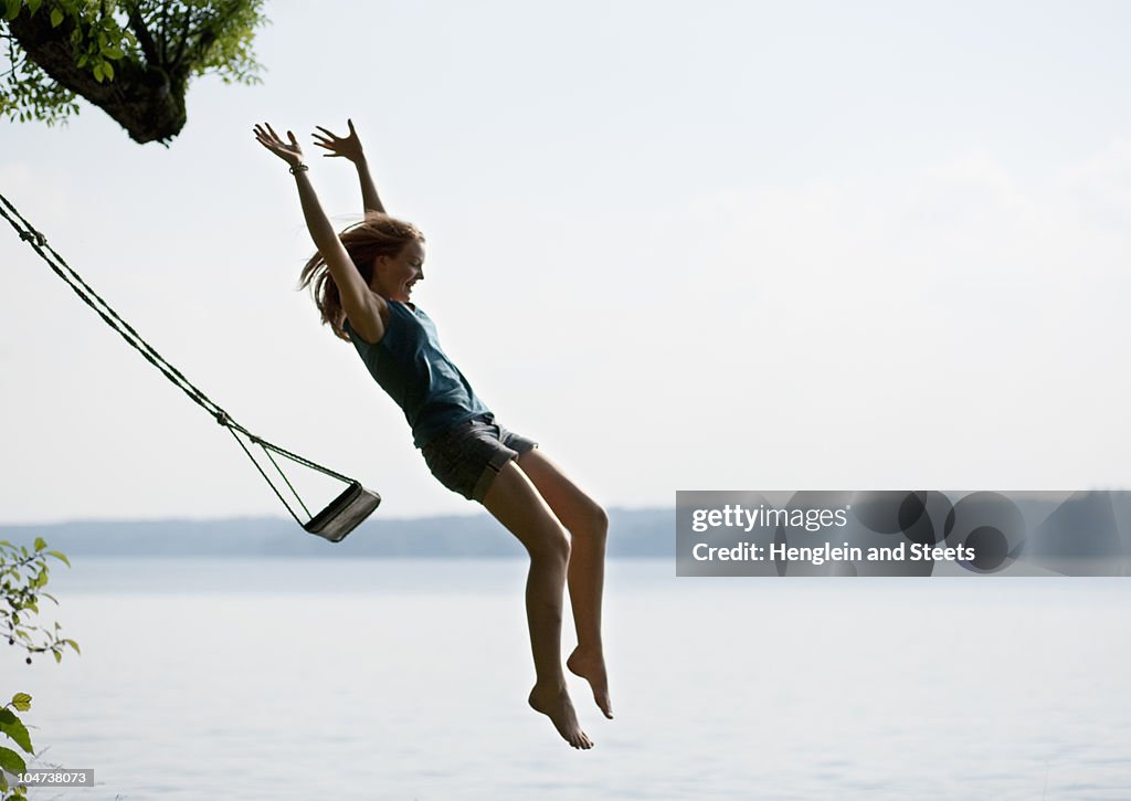 Girl jumping from swing