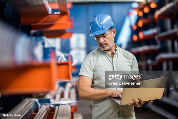 quality control inspector using laptop in industrial building. - steel mill stock pictures, royalty-free photos & images