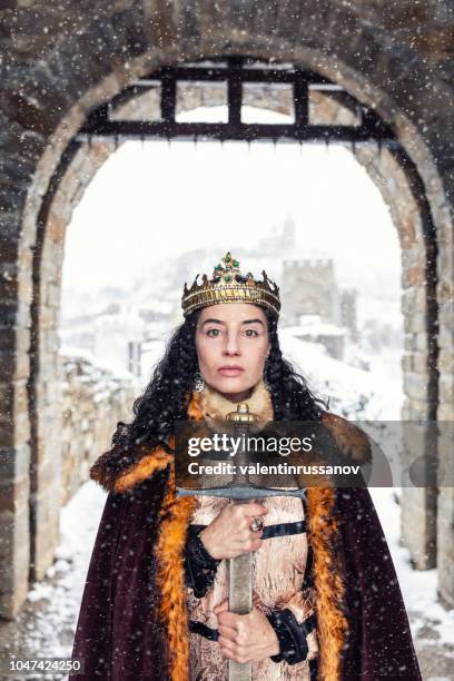 portrait of a queen in front of her castle, holding a sword - medieval queen crown imagens e fotografias de stock