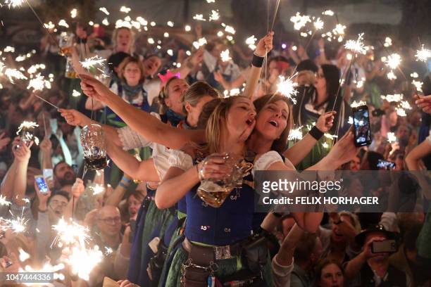 Hostesses dance on tables in one of the main beer tents on the last day of the Octoberfest in Munich on October 7, 2018. - The "oktoberfest" is the...