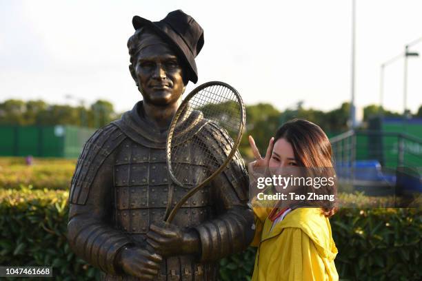 Girl takes photo with Roger Federer of Switzerland statue at Qi Zhong Tennis Centre on October 8, 2018 in Shanghai, China.