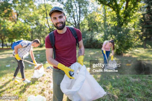 jonge vrijwilligers camera kijken - male volunteer stockfoto's en -beelden