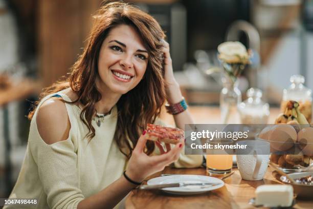 junge lächelnde frau mit frühstück in der küche. - marmalade sandwich stock-fotos und bilder