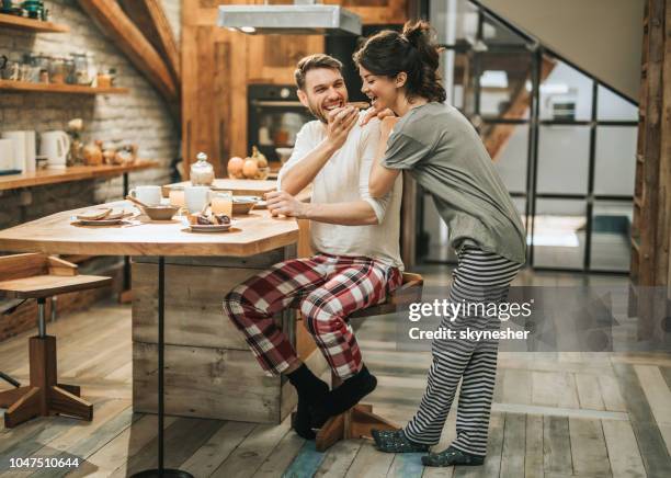 casal feliz se divertindo durante o pequeno-almoço na cozinha. - pijama - fotografias e filmes do acervo