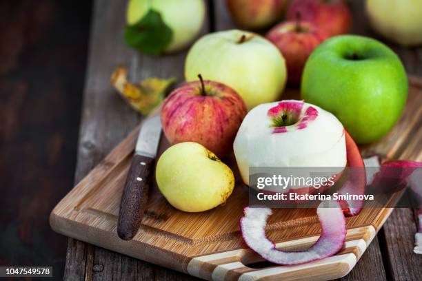 fresh ripe colorful apples on cutting board, rustic background - cutting green apple stock pictures, royalty-free photos & images