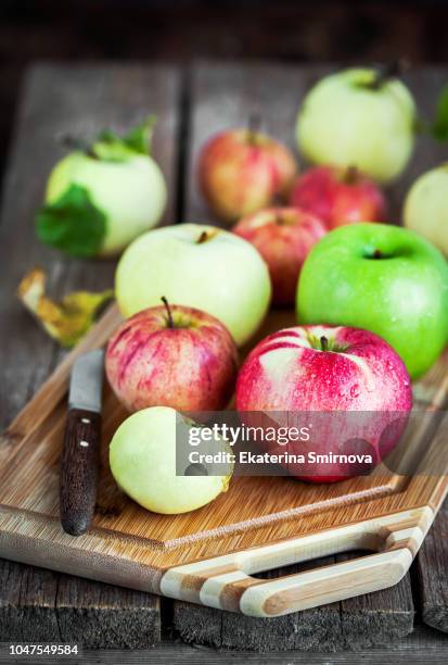 fresh ripe colorful apples on cutting board, rustic background - cutting green apple stock pictures, royalty-free photos & images