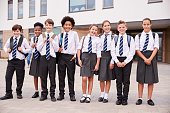 Portrait Of High School Student Group Wearing Uniform Standing Outside School Buildings