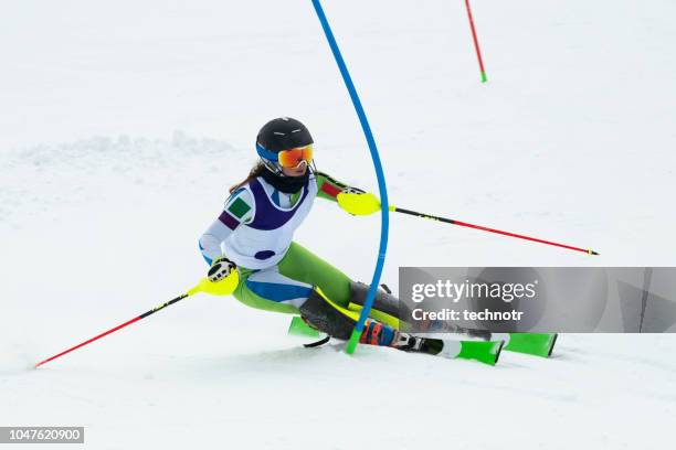 young women at slalom skiing passing the blue gate - ski slalom stock pictures, royalty-free photos & images