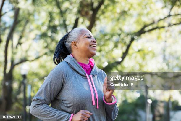 mature african-american woman jogging in city - speed walking stock pictures, royalty-free photos & images