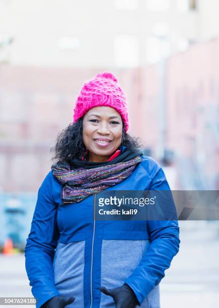 senior african-american woman, knit hat, gloves in city - winter hat stock pictures, royalty-free photos & images