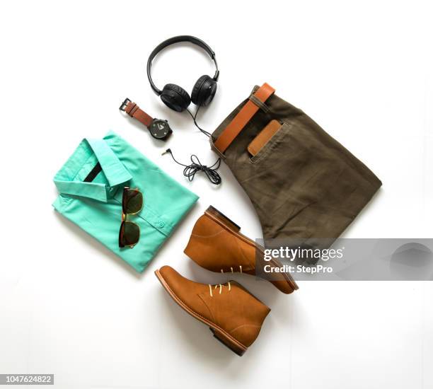 Men's casual outfits for man clothing with ankle boot , watch, sunglasses, trousers, earphone, shirt and wallet isolated on white background, Top view. pack shot