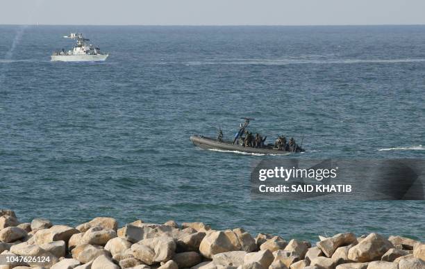 Israeli navy personnel keep watch from boats as Palestinian protestors stage a demonstration on the beach near the maritime border with Israel, in...