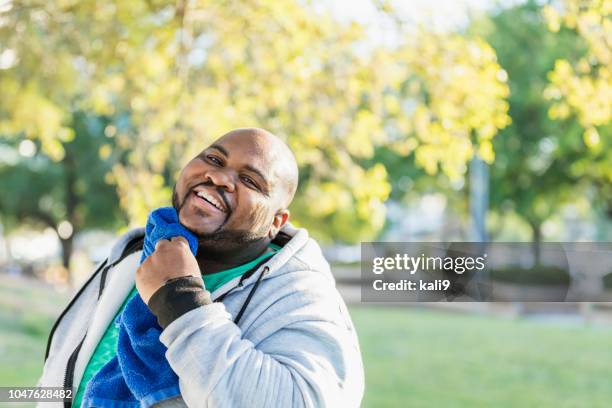 hombre limpiando la cara con la toalla después de hacer ejercicio - cara hombre gordo fotografías e imágenes de stock