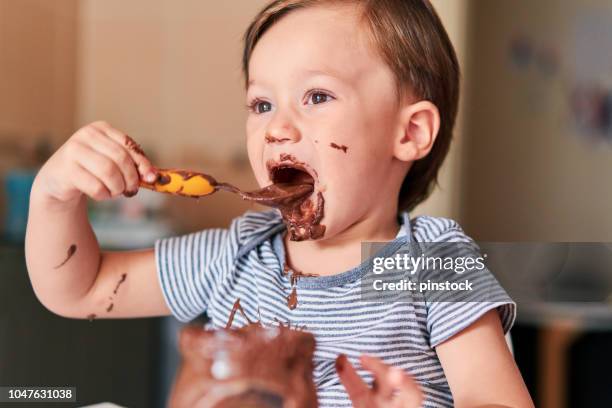 child is eating chocolate - chocolate spread stock pictures, royalty-free photos & images