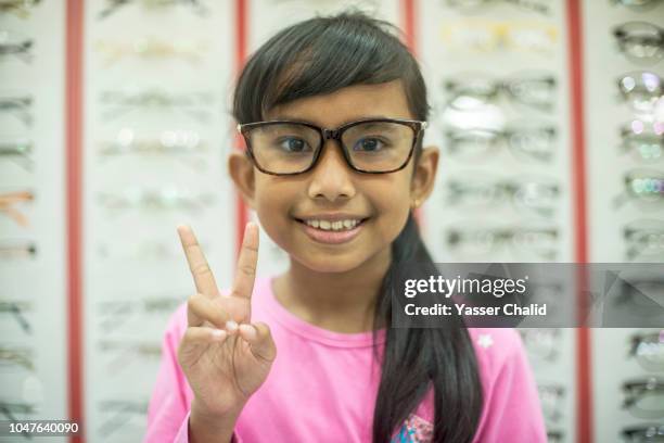 girl try new eyeglasses - asian child with new glasses ストックフォトと画像