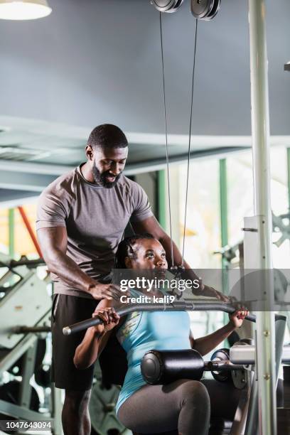 personal trainer helping mature woman at gym - personal trainer stock pictures, royalty-free photos & images