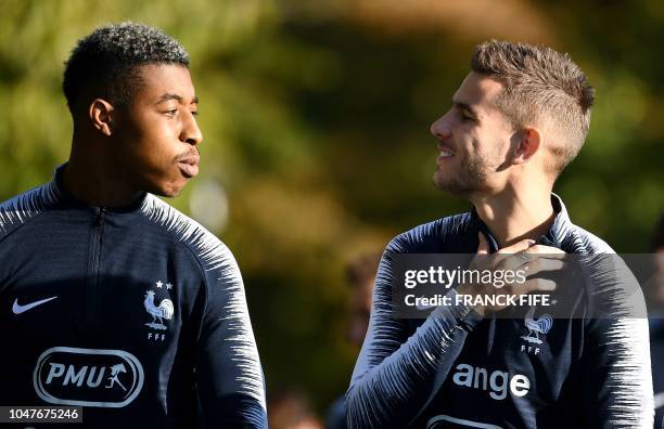 France's defender Presnel Kimpembe speaks with France's defender Lucas Hernandez before a training session in Clairefontaine en Yvelines on October 8...