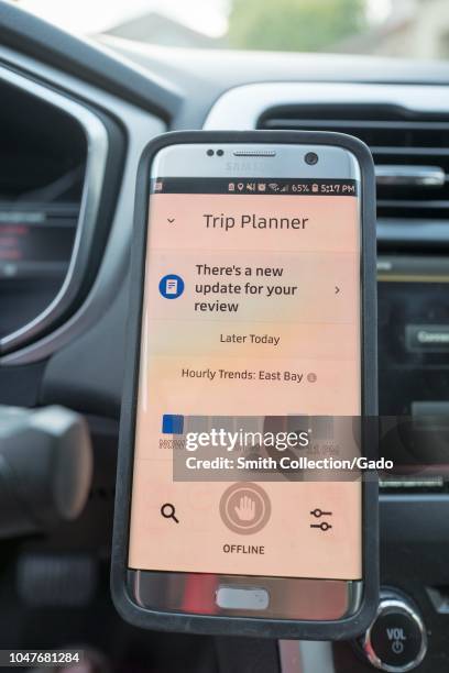 Close-up of a smartphone displaying the Uber driver app and trip planner feature for the East Bay regional of the San Francisco Bay Area, installed...