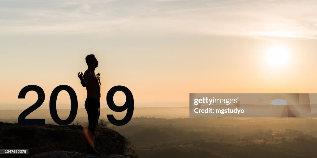 Man  practicing yoga during the celebration New Year 2019