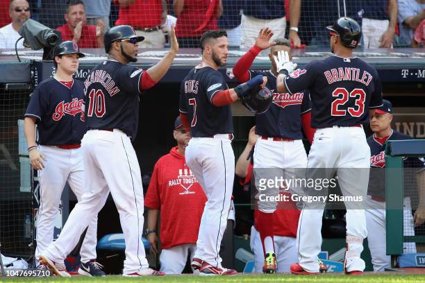Michael Brantley celebrates with teammates at the dugout after hitting a sacrifice fly ball to score Yan Gomes of the Cleveland Indians in the third...