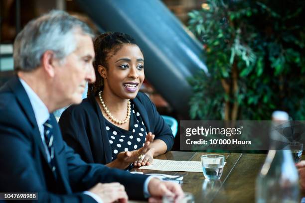 woman next to male manager in business meeting - mentoring foto e immagini stock