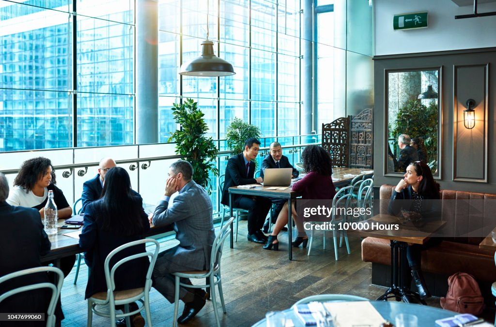 Business people having working lunch in restaurant