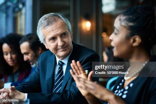 contented senior professional businessman listening to young colleague - showing respect bildbanksfoton och bilder