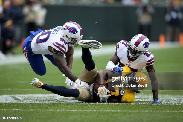 Davante Adams of the Green Bay Packers is tackled by Ramon Humber and Tre'Davious White of the Buffalo Bills in the first quarter at Lambeau Field on...