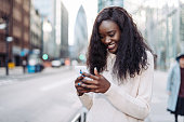 Beautiful black woman using mobile phone near Aldgate in London