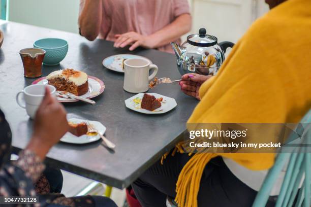 close up of mature woman's hands as they sit  around a table eating cake - cunhada imagens e fotografias de stock