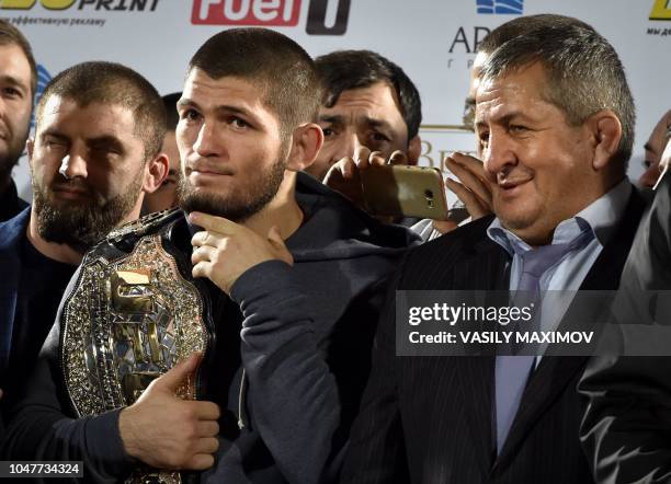 Lightweight champion Khabib Nurmagomedov of Russia holds his champions belt next to his father Abdulmanap during a ceremony upon the arrival at the...