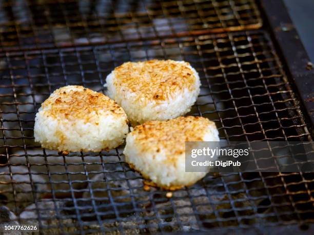 grill rice balls on metal grill grate sold on the street during jazz de bon odori event in yokohama - rice ball stock pictures, royalty-free photos & images