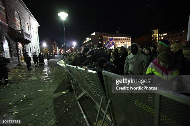 Riot police put up steel fences and stand guard in front of the Icelandic Parliament house as thousands of people are protesting the governments...