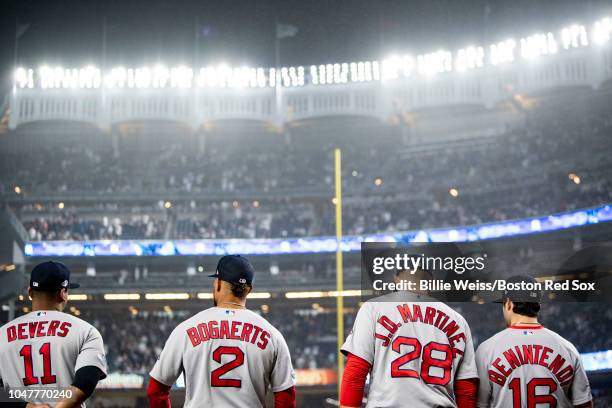 Rafael Devers, Xander Bogaerts, J.D. Martinez, and Andrew Benintendi of the Boston Red Sox look on before game three of the American League Division...